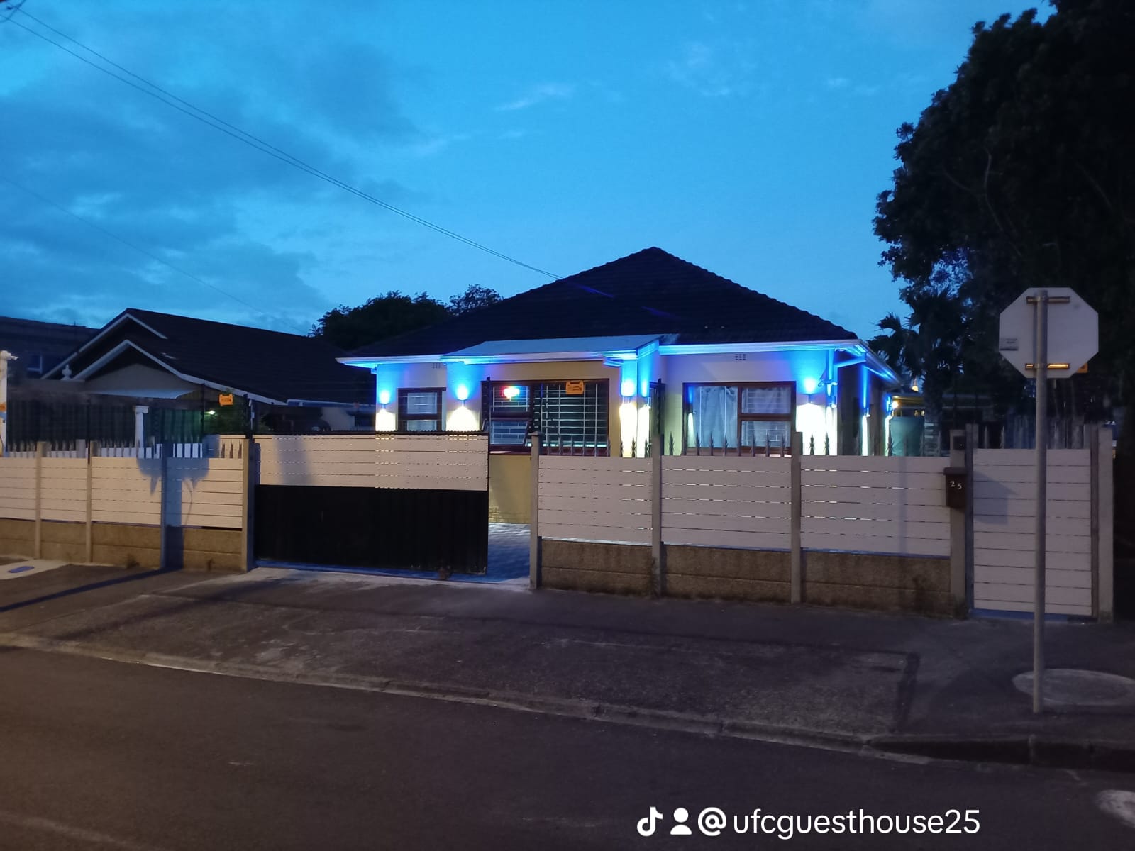 UFC Guest House exterior lit in blue at dusk